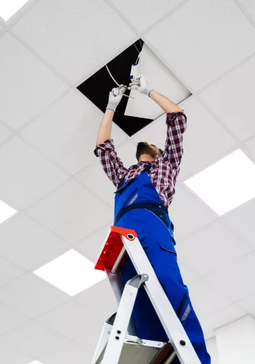 man installing light on top ladder